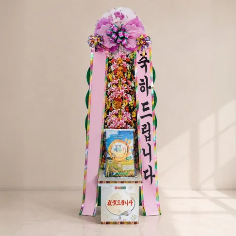 달자네꽃배달 쌀화환 10kg 89,000원. 세로로 길게 올린 꽃탑 아래 받침 자리에 10kg 쌀 한 포대를 얹은 형태로, 분홍 리본에 '축하드립니다'를 세로로 적어 내렸다.